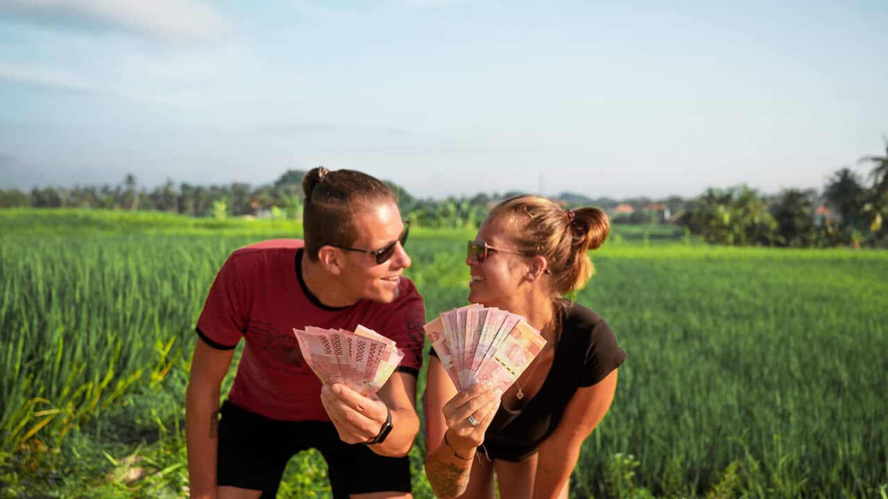 Ein Bündel indonesischer Rupiah-Scheine in der Hand - Bargeld ist in Indonesien unverzichtbar