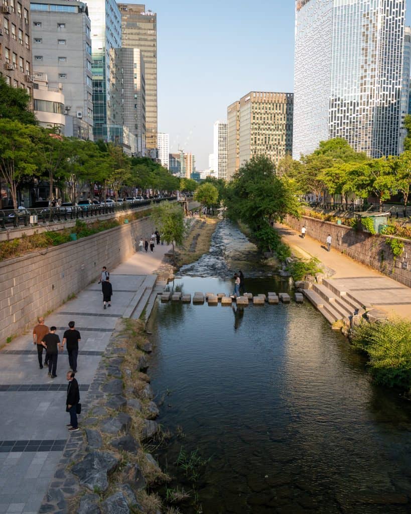 Locals entspannen am Cheonggyecheon Stream in Seoul zwischen Wolkenkratzern