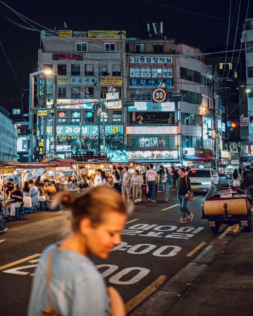 Schmale Gasse in Seoul mit bunter Leuchtreklame und traditionellen Restaurants bei Nacht