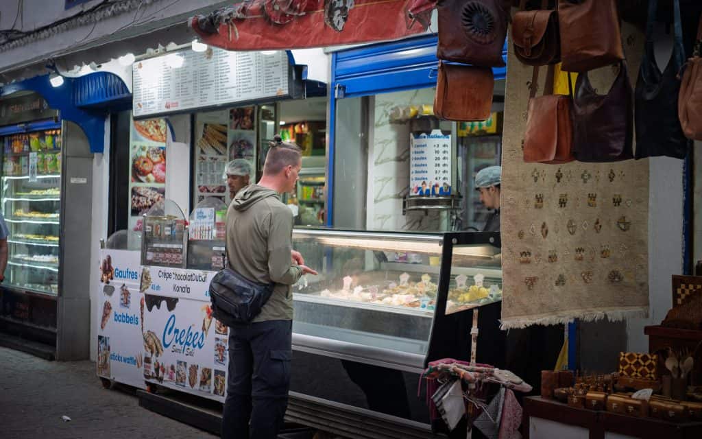 Marco bezahlt an einem Straßenstand in Marokko ein Eis mit Bargeld – Bezahlen in Marokko