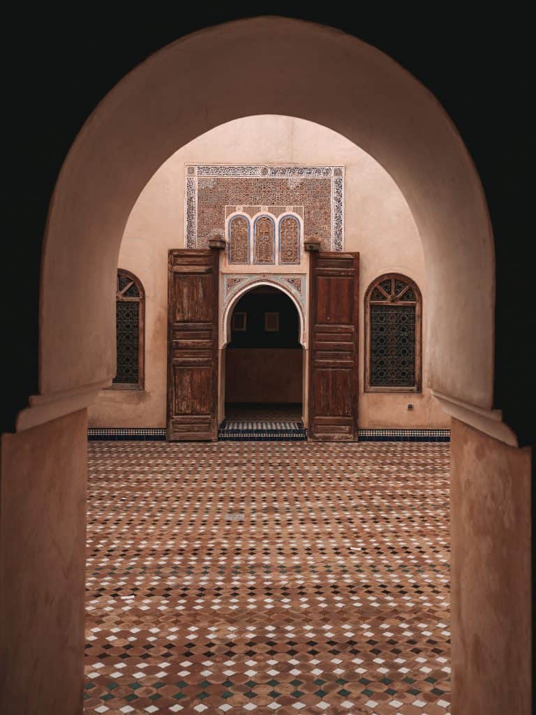 Blick durch einen Türrahmen in einen Innenhof des Bahia-Palasts in Marrakesch